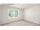 Bedroom featuring neutral carpet, white walls, and a window overlooking a neighboring house at 134 Asmodean Ln, Troutman, NC 28166
