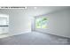 Bedroom with neutral carpet, an ensuite bathroom, and a window overlooking the lawn at 134 Asmodean Ln, Troutman, NC 28166