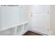 Bright mudroom with a bench and storage cubes next to the white front door and lovely wood floors at 134 Asmodean Ln, Troutman, NC 28166