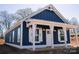 Charming blue home with white trim, a covered porch, and board and batten siding offers curb appeal at 1432 Blackbird Dr, Clover, SC 29710