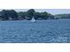 Picturesque lake view featuring a sailboat gliding across the water on a beautiful sunny day at 18009 Kings Point Dr # C, Cornelius, NC 28031