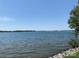 Expansive waterfront view showcasing the tranquil lake and the community shoreline with mature trees at 18009 Kings Point Dr # C, Cornelius, NC 28031