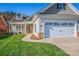 Inviting home featuring a welcoming front porch and attached two-car garage with stone accents at 229 River Birch Dr, Salisbury, NC 28146