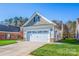 Two car garage with stone accents and a well manicured front lawn at 229 River Birch Dr, Salisbury, NC 28146