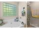 Bathroom with a tub, glass block window, and decorative floral shower curtain at 2341 Shannon Dr, Belmont, NC 28012