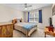 Cozy bedroom with a comfortable bed, dresser, and a window with blue curtains at 2341 Shannon Dr, Belmont, NC 28012