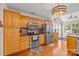 Well-lit kitchen featuring stainless steel appliances, wood cabinets, granite counters, and wood flooring at 2341 Shannon Dr, Belmont, NC 28012