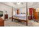 Spacious main bedroom with a four-poster bed, tray ceiling, neutral walls, and red curtains at 2341 Shannon Dr, Belmont, NC 28012