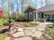 Landscaped backyard featuring a stone patio, fountain, and lush greenery, perfect for outdoor relaxation and entertaining at 2342 Wesley Landing Rd, Waxhaw, NC 28173