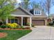 Charming home featuring a manicured front yard, stone and siding exterior, and an attached garage at 2342 Wesley Landing Rd, Waxhaw, NC 28173