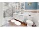 Modern bathroom featuring double sinks, neutral tiling, and a glass door shower enclosure at 2482 Kings Grant Rd, Lincolnton, NC 28092