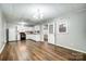 Open-concept kitchen with white cabinetry, adjacent dining area, and wood floors at 26 Park Dr, Gastonia, NC 28054