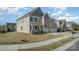Well-maintained two-story home with a charming front porch and a three-car garage and manicured lawn at 276 Annatto Way, Tega Cay, SC 29708