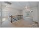 Upstairs hallway with carpet, railing, and entry to rooms, providing a transition between living spaces at 276 Annatto Way, Tega Cay, SC 29708