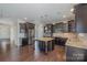 Modern kitchen featuring dark cabinetry, stainless steel appliances, granite counters, and a center island at 276 Annatto Way, Tega Cay, SC 29708