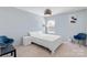 Light and airy bedroom featuring carpet floors, neutral tones, and two comfortable blue chairs at 3124 Berry Creek Rd, Charlotte, NC 28214