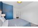 Comfortable bedroom featuring a blue accent wall and access to a bathroom and closet space at 3124 Berry Creek Rd, Charlotte, NC 28214