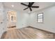 Bright bedroom with laminate floors and a modern ceiling fan leading into the bathroom at 3225 Liberty Rd, Gold Hill, NC 28071