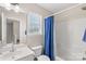 Bright bathroom featuring a single sink vanity, commode, and shower with blue curtain at 3904 Crimson Wing Dr, Indian Trail, NC 28079