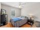 Well-lit bedroom featuring a ceiling fan, hardwood flooring, and a comfortable bed at 3904 Crimson Wing Dr, Indian Trail, NC 28079