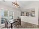 Dining area featuring a modern light fixture and views of the outdoor pool at 3904 Crimson Wing Dr, Indian Trail, NC 28079