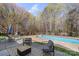 Outdoor patio with furniture, fire pit, and a pool surrounded by mature trees at 3904 Crimson Wing Dr, Indian Trail, NC 28079