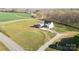An aerial view of a modern farmhouse-style home, surrounded by a large, green lawn and mature trees at 3907 E Lawyers Rd, Monroe, NC 28110