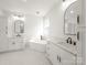 Bright, spacious bathroom featuring a soaking tub, dual sinks, framed mirrors, and marble countertops at 3907 E Lawyers Rd, Monroe, NC 28110