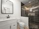 Modern bathroom featuring a glass shower with decorative tiles, a black faucet, and a framed mirror at 3907 E Lawyers Rd, Monroe, NC 28110