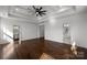 Large bedroom with hardwood floors, tray ceilings, ceiling fan, and doors to walk-in closet and bathroom at 3907 E Lawyers Rd, Monroe, NC 28110