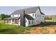 This home has an impressive exterior with black accents, white siding, a chimney, and a covered patio at 3907 E Lawyers Rd, Monroe, NC 28110