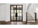 Light-filled foyer with a staircase, dark wood floors, and a stylish front door with grid design at 3907 E Lawyers Rd, Monroe, NC 28110