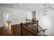 Hallway with hardwood floors, wood railing staircase, white wainscoting, and a decorative light fixture at 3907 E Lawyers Rd, Monroe, NC 28110