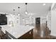 Bright open kitchen with large island, modern lighting, stainless appliances, and access to the living room and backyard at 3907 E Lawyers Rd, Monroe, NC 28110