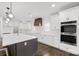 New kitchen features stainless appliances, double ovens, white cabinets, island with countertop, modern fixtures, and hardwood floors at 3907 E Lawyers Rd, Monroe, NC 28110