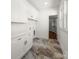 Bright laundry room with white cabinets, marbled floors, and a view into a walk-in closet at 3907 E Lawyers Rd, Monroe, NC 28110