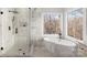Luxurious bathroom featuring a soaking tub, a walk-in shower, and elegant marble finishes at 4012 Cambridge Hill Ln, Charlotte, NC 28270