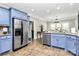 Open concept kitchen with stainless steel appliances, blue cabinets, and granite countertops overlooking dining area at 4205 New Town Rd, Waxhaw, NC 28173