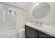 Bathroom features a combination shower and tub, a white sink and vanity, and a window for natural light at 4601 Crooked Oak Ln, Charlotte, NC 28226