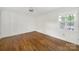 Bedroom with hardwood floors, a ceiling fan, a window with natural light, and a closet with white doors at 4601 Crooked Oak Ln, Charlotte, NC 28226