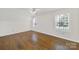 Attic bedroom featuring hardwood floors, white walls, white trim, and a window with natural light at 4601 Crooked Oak Ln, Charlotte, NC 28226