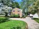 Traditional brick home with lush landscaping and a winding driveway creates a warm and welcoming atmosphere at 4601 Crooked Oak Ln, Charlotte, NC 28226