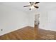 Hallway with hardwood floors, white walls, white trim, and a view into an adjacent bedroom or room at 4601 Crooked Oak Ln, Charlotte, NC 28226
