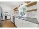 Bright kitchen features granite countertops, floating shelves, white subway tile backsplash and stainless steel appliances at 4601 Crooked Oak Ln, Charlotte, NC 28226