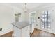 Kitchen island with granite countertop, pendant lighting, white cabinets, and access to outdoor living at 4601 Crooked Oak Ln, Charlotte, NC 28226