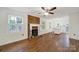 Bright living room features a brick fireplace, hardwood flooring, and open access to the kitchen and dining at 4601 Crooked Oak Ln, Charlotte, NC 28226