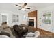Bright living room features a brick fireplace, ceiling fan, neutral paint, and hardwood flooring at 4601 Crooked Oak Ln, Charlotte, NC 28226