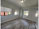 Cozy bedroom with wood-look flooring and natural light from multiple windows at 715 N Church St # 301, Charlotte, NC 28202