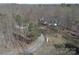 An aerial shot of a sprawling property featuring a white home with mature trees and a gravel driveway at 7218 Alexander Farm Rd, Monroe, NC 28110