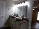 Bathroom featuring a double sink vanity with stone bowl sinks, decorative faucets and a large mirror at 7218 Alexander Farm Rd, Monroe, NC 28110